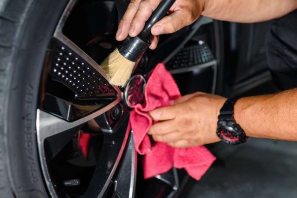 Nettoyage minutieux de jantes au look urbain avec brosse spécialisée et chiffon microfibre rouge