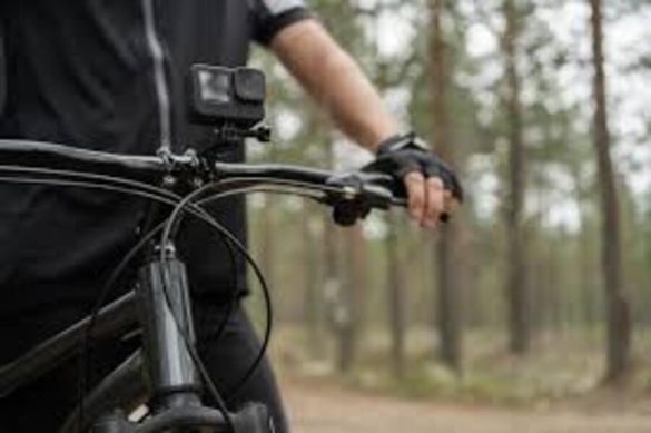 Caméras de sport tout-terrain fixées sur guidon de VTT dans environnement forestier pour capture d'action