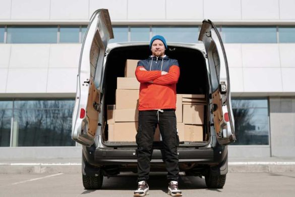 Livreur professionnel devant sa camionnette chargée de colis utilisant un système de geofencing pour optimiser ses livraisons