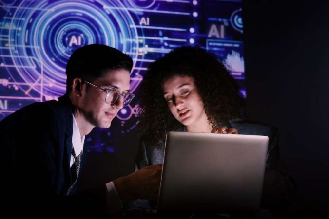 Un homme et une femme analysent un ordinateur portable devant un écran affichant des graphiques technologiques et le texte AI.